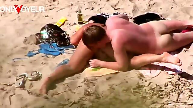 Young man and girlfriend get naughty on sunny beach